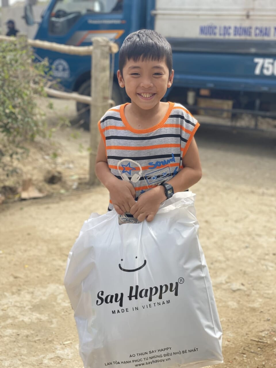 Đứa trẻ vui cười khi nhận quà cứu trợ Say Happy